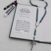 Two dry-erase prayer tracker stickers on inside cover of journal, with dry-erase marker and crayon and Rosary
